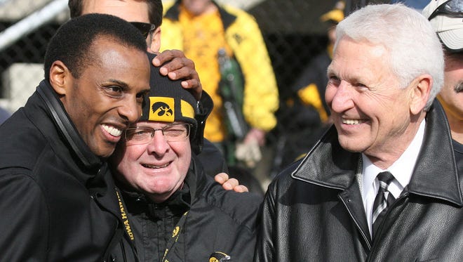 Former Iowa basketball player Ronnie Lester shares a moment with athletic trainer John Streif, center, and former coach Lute Olson in 2009 at Kinnick Stadium.