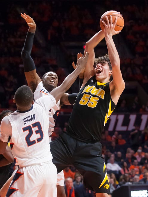 Iowa forward Luka Garza (55) secures a rebound while being defended by Illinois guard Aaron Jordan (23) during their game Thursday, Jan. 11, 2018, in Champaign, Illinois.