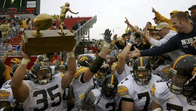With the black-and-gold faithful chanting "Hawkeye State! Hawkeye State!" Iowa's Erik Jensen hoists the Cy-Hawk trophy after the Hawkeyes beat Iowa State, 40-21, Sept. 13, 2003 in Ames.