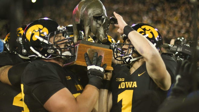 Iowa seniors Austin Blythe, left, and Marshall Koehn carry the Floyd of Rosedale trophy after putting up a win over Minnesota on Saturday, Nov. 14, 2015, at Kinnick Stadium in Iowa City.