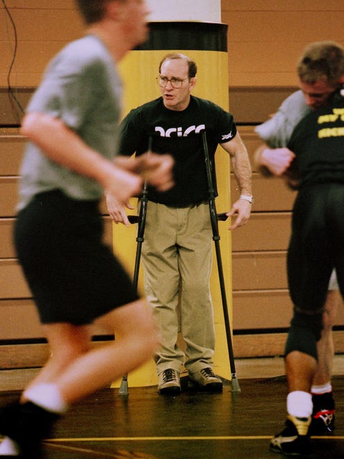 In this March 18, 1997 photo and still recuperating from hip-replacement surgery, Dan Gable relies on crutches as he supervises his wrestlers during a workout.