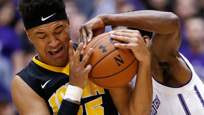 Iowa forward Cordell Pemsl, left, battles for a loose ball against Northwestern forward Vic Law during the first half of an NCAA college basketball game Sunday, Jan. 15, 2017, in Evanston, Ill. (AP Photo/Nam Y. Huh)