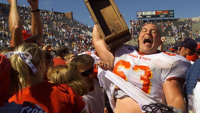 Iowa State offensive lineman Ben Bruns raises the Cy-Hawk trophy in celebration of the Cyclones' 24-14 win against Iowa on Sept. 16, 2000 at Kinnick Stadium in Iowa City.