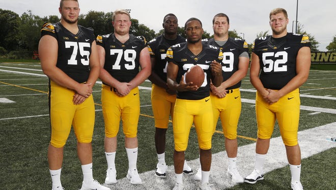 Iowa guard Sean Welsh (79) is the leader of an offensive line looking to pave the way for another 1,000-yard rushing season by Akrum Wadley (25). Welsh was named a second team Sports Illustrated preseason all-American.