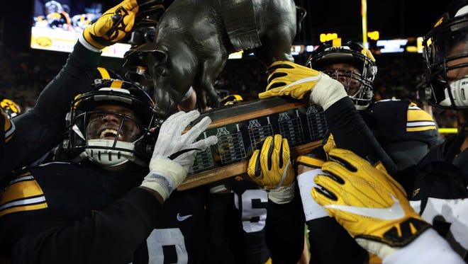 Iowa's Miles Taylor helps carry Floyd of Rosedale following the Hawkeyes' 17-10 win over Minnesota at Kinnick Stadium on Saturday, Oct. 28, 2017.
