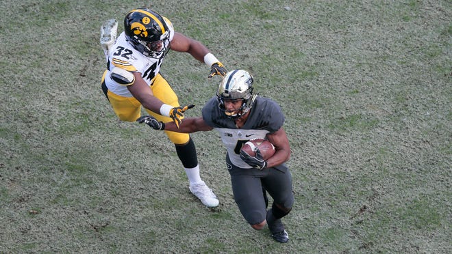 Purdue wide receiver Rondale Moore (4) runs from Iowa linebacker Djimon Colbert (32) in the first half of an NCAA college football game in West Lafayette, Ind., Saturday, Nov. 3, 2018. Purdue won 38-36. (AP Photo/AJ Mast)