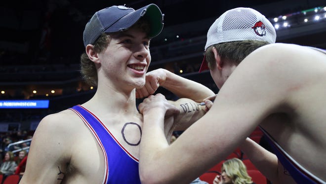 Reece Roberts and Reid Ehman, students at Dike New Hartford High School write "Dilly Dilly" on their arms before the championship round of the class 2A Iowa high school state wrestling tournament on Saturday, Feb. 17, 2018, in Wells Fargo Arena.