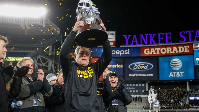 Iowa head football coach Kirk Ferentz raises the 2017 Pinstripe Bowl trophy after leading the Hawkeyes to a 27-20 win over Boston College in the 2017 Pinstripe Bowl at Yankee Stadium in Bronx, New York on Wednesday, Dec. 27, 2017.