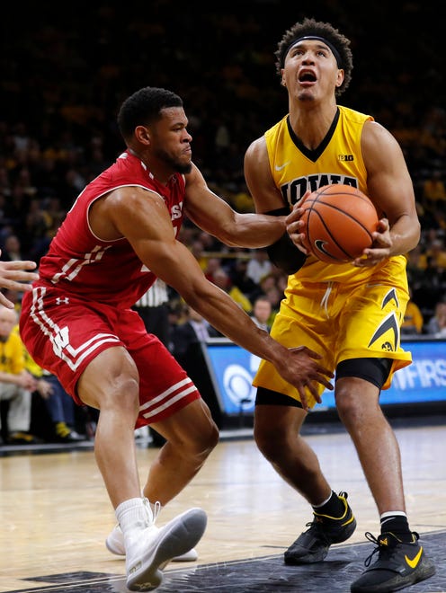 Iowa forward Cordell Pemsl is fouled by Wisconsin forward Charles Thomas IV, left, while driving to the basket during the second half of an NCAA college basketball game Tuesday, Jan. 23, 2018, in Iowa City, Iowa. Iowa won 85-67. (AP Photo/Charlie Neibergall)