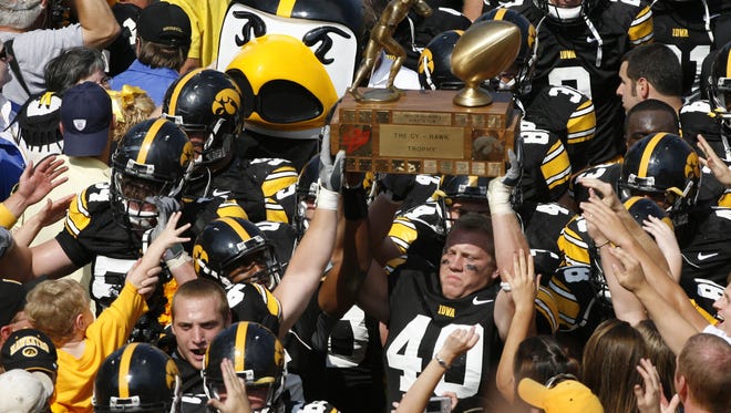 Iowa's Mike Klinkenborg (40) raises the Cy-Hawk trophy high in the air in celebration of the Hawkeyes' 27-17 win Sept. 16, 2006 at Kinnick Stadium in Iowa City.