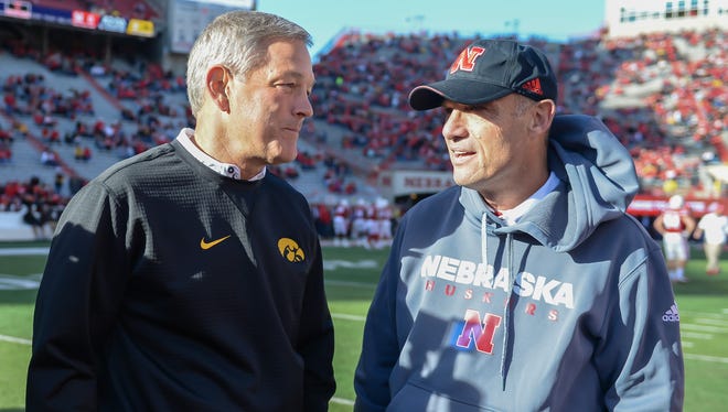 Head coach Kirk Ferentz of the Iowa Hawkeyes and head coach Mike Riley of the Nebraska Cornhuskers meet on the field before the game at Memorial Stadium on November 24, 2017 in Lincoln, Nebraska.