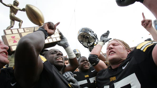 Iowa defensive lineman Mitch King, right, and defensive back Harold Dalton lead the Hawkeyes in the Iowa fight song while teammates jubilantly hoist the Cy-Hawk Trophy after defeating Iowa State, 17-5, at Kinnick Stadium in Iowa City on Saturday Sept. 13, 2008.