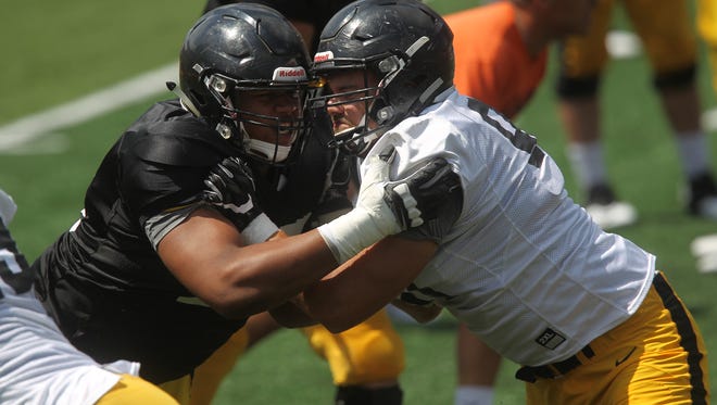 Iowa offensive lineman Alaric Jackson (left) locks up defensive end Sam Brincks during the open practice on Kids Day at Kinnick Stadium on Saturday. Jackson, a redshirt freshman, saw a lot of action with the first unit.