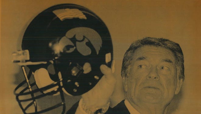 Coach Hayden Fry holds an Iowa helmet with an American flag decal that the team will wear in the 1991 Rose Bowl to show support for the military. Fry was showing the helmet at a news conference in Newport Beach, Calif.