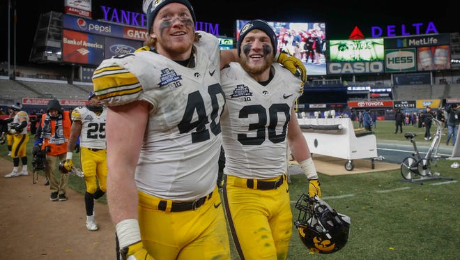 Iowa juniors Parker Hesse, left, and Jake Gervase make their way off the field at Yankee Stadium after helping the Hawkeyes to a 27-20 win over Boston College during the 2017 Pinstripe Bowl in Bronx, New York on Wednesday, Dec. 27, 2017.