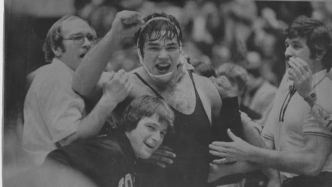 In this 1977 photo, Iowa coach Dan Gable leads the celebration after the top-ranked Hawkeyes raced to tie Iowa State 17-17. Also pictured: John Bowlsby (rear), Keith Mourlam and assistant coach Jay Robinson. Iowa trailed 14-5 after six bouts.