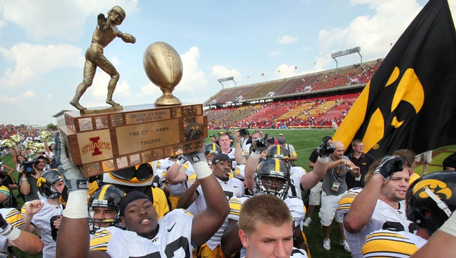 Iowa offensive lineman Adam Gettis (73) carries the Cy-Hawk trophy off the Jack Trice Stadium field following the Hawkeyes' 35-3 win over Iowa State on Saturday, Sept. 12, 2009.