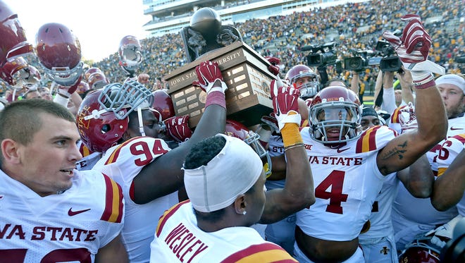 Iowa State players celebrate with the Cy-Hawk Trophy in front of their fans after a 20-17 win over Iowa at Kinnick Stadium in Iowa City on Saturday, Sept. 13, 2014.