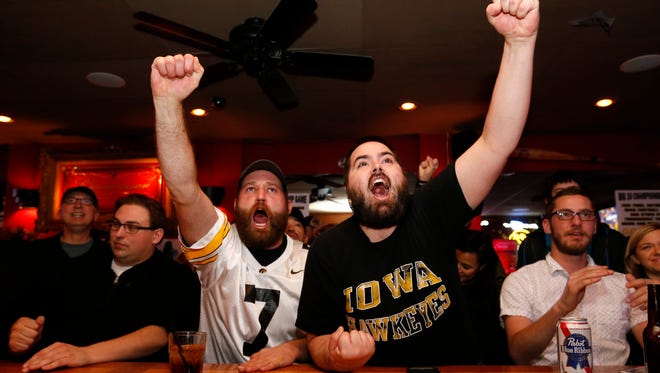 Todd Ownes of Avoca (left) and CJ Ertelt of Grimes celebrate a Hawkeyes stop on Michigan State Saturday Dec. 5, 2015, during a Big 10 championship watch party at Beechwood Lounge in Des Moines.