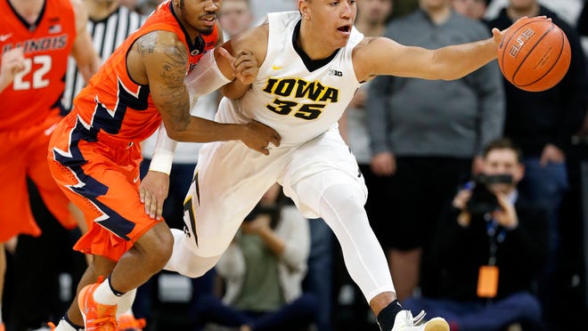 Illinois guard Jaylon Tate, left, fights for a loose ball with Iowa forward Cordell Pemsl during the second half of an NCAA college basketball game, Saturday, Feb. 18, 2017, in Iowa City, Iowa. Illinois won 70-66. (AP Photo/Charlie Neibergall)