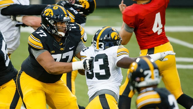 Redshirt freshman Alaric Jackson (77), right, holds the line against freshman defensive end Brandon Simon (93) during the April 21 spring game. Jackson (6-5, 320) could be working his way into the Hawkeyes' 2017 offensive-line rotation.