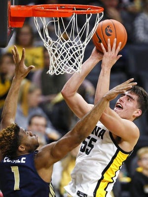 Iowa center Luka Garza (55) drives to the basket over Oral Roberts forward Elijah Lufile during the game in Iowa City.