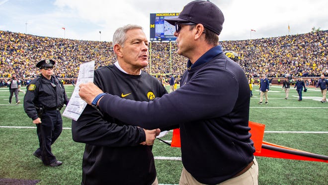 Iowa head coach Kirk Ferentz, left, shakes hands with Michigan head coach Jim Harbaugh, right, after an NCAA college football game in Ann Arbor, Mich., Saturday, Oct. 5, 2019. Michigan won 10-3. (AP Photo/Tony Ding)
