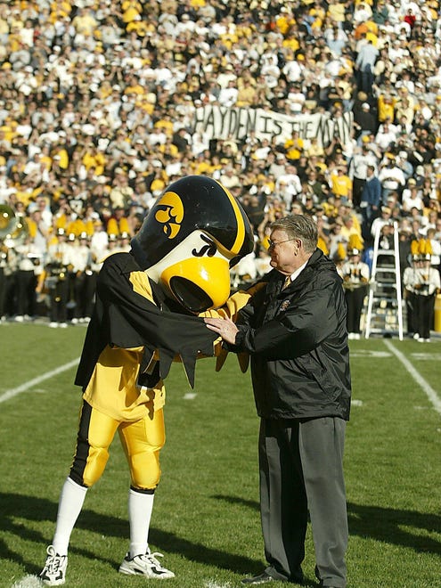 Former Iowa head coach Hayden Fry shakes hands with Herky during a halftime presentation Oct 4, 2003.