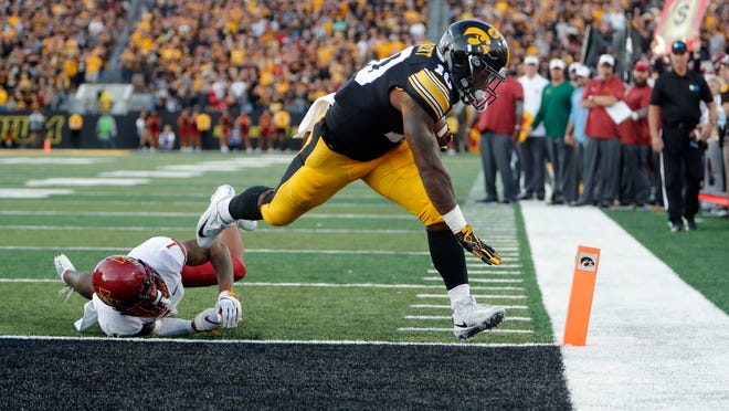 Iowa running back Mekhi Sargent, right, slips out of the hands of Iowa State defensive back D'Andre Payne, left, to score a touchdown during the second half of an NCAA college football game, Saturday, Sept. 8, 2018, in Iowa City, Iowa. Iowa won 13-3. (AP Photo/Matthew Putney)