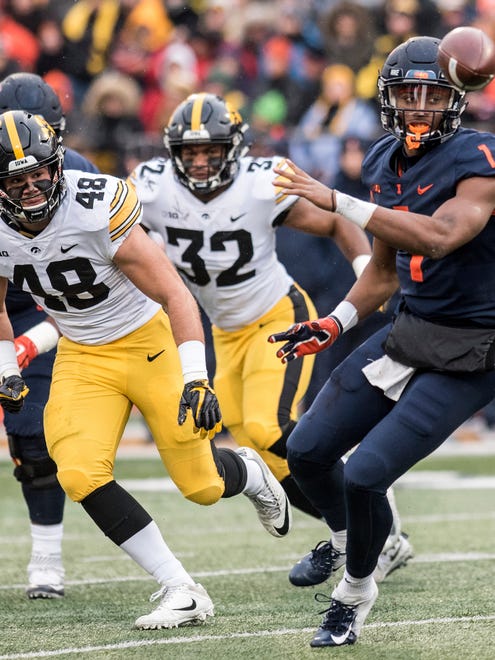 Illinois quarterback A.J. Bush, Jr. (1) throws a shuffle pass as Iowa's Jack Hockaday (48) and Djimon Colbert (32) defend in the first half of a NCAA college football game, Saturday, Nov. 17, 2018, in Champaign, Ill. (AP Photo/Holly Hart)