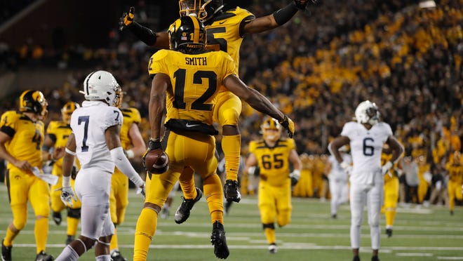 Iowa running back Tyler Goodson, top, congratulates wide receiver Brandon Smith on his touchdown during the second half of an NCAA college football game against Penn State, Saturday, Oct. 12, 2019, in Iowa City, Iowa. Penn State won 17-12. (AP Photo/Matthew Putney)
