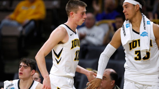 Iowa guard Joe Wieskamp is greeted by teammate Cordell Pemsl, right, at the end of an NCAA college basketball game against UKMC, Thursday, Nov. 8, 2018, in Iowa City, Iowa. (AP Photo/Charlie Neibergall)