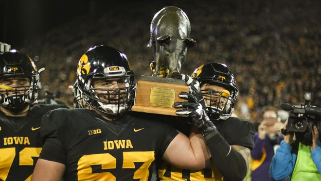 Iowa seniors Austin Blythe, left, and Melvin Spears carry the Floyd of Rosedale trophy after putting up a win over Minnesota on Saturday, Nov. 14, 2015, at Kinnick Stadium in Iowa City.