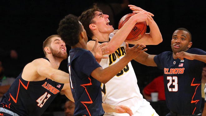 Iowa Hawkeyes forward Luka Garza (55) grabs a rebound against Illinois Fighting Illini forward Michael Finke (43) and guard Trent Frazier (1) and guard Aaron Jordan (23) during the second half of a first round game of the 2018 Big Ten Tournament at Madison Square Garden.