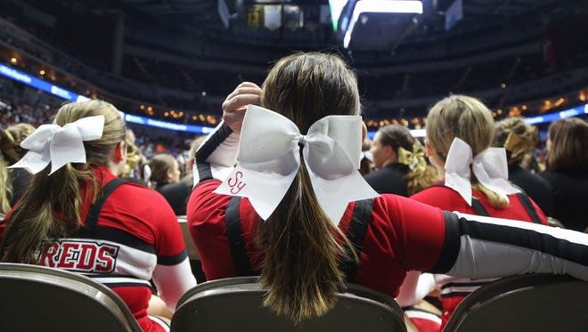Cheerleaders wait on the edge of the arena floor before the star of the championship round of the class 2A Iowa high school state wrestling tournament on Saturday, Feb. 17, 2018, in Wells Fargo Arena.