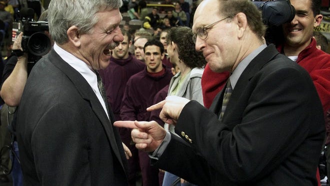 In this March 17, 2001 photo and at right, Minnesota's J Robinson takes a ribbing from former Iowa coach Dan Gable, right, his ex-boss. Minnesota won its first team title under Robinson.