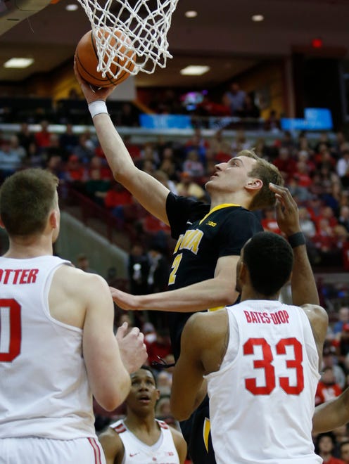 Iowa forward Jack Nunge, center, goes up for a shot between Ohio State center Micah Potter, left, and forward Keita Bates-Diop during the first half of an NCAA college basketball game in Columbus, Ohio, Saturday, Feb. 10, 2018. (AP Photo/Paul Vernon)