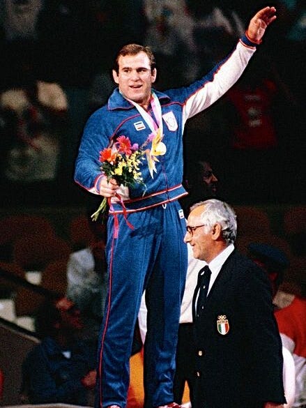 Wrestler Ed Banach accepts his gold medal during the 1984 Olympic Games.