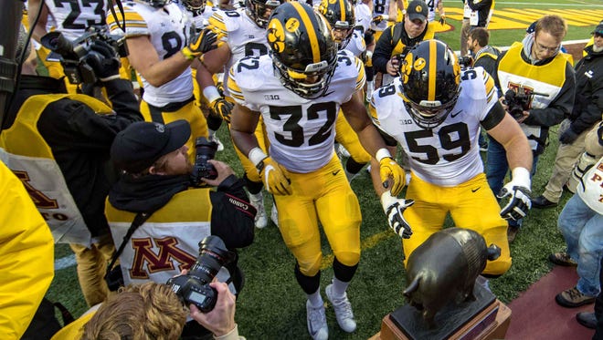 The Iowa Hawkeyes run to grab the Floyd of Rosedale trophy after defeating the Minnesota Golden Gophers at TCF Bank Stadium on Saturday, Oct. 6, 2018.