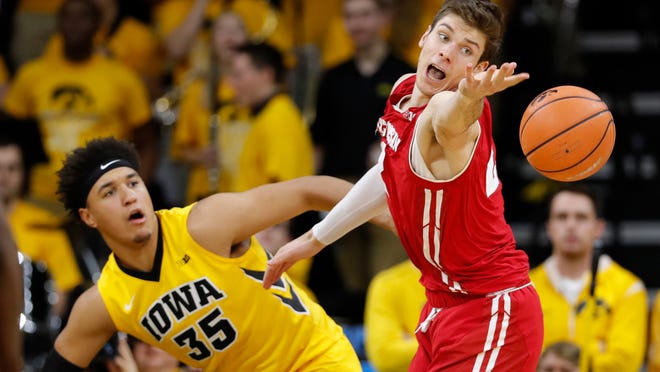Wisconsin forward Ethan Happ tries to steal the ball from Iowa forward Cordell Pemsl, left, during the second half of an NCAA college basketball game Tuesday, Jan. 23, 2018, in Iowa City, Iowa. (AP Photo/Charlie Neibergall)