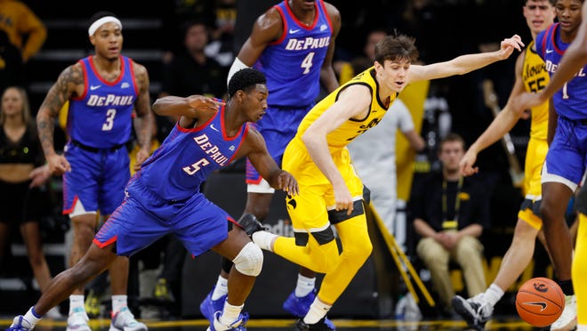 DePaul guard Jalen Coleman-Lands (5) fights for a loose ball with Iowa forward Patrick McCaffery during the first half of an NCAA college basketball game, Monday, Nov. 11, 2019, in Iowa City, Iowa. (AP Photo/Charlie Neibergall)