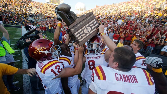 Iowa State players celebrate a 9-6 victory over Iowa by carrying the the Cy-Hawk Trophy off the field on Saturday, Sept. 8, 2012, at Kinnick Stadium in Iowa City.