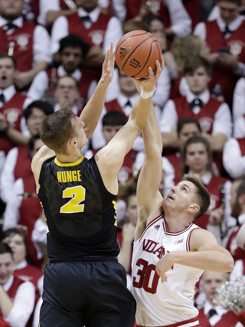 Iowa's Jack Nunge puts up a shot against Indiana's Collin Hartman during the second half of an NCAA college basketball game, Monday, Dec. 4, 2017, in Bloomington, Ind. Indiana won 77-64. (AP Photo/Darron Cummings)