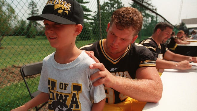 From 1998: Iowa defensive lineman Jared DeVries autographs Peter Van Voorhis' T-shirt during Hawkeyes football media/fan day in Iowa City.