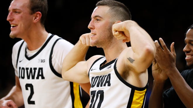 Iowa' Connor McCaffery, second from left, and Jack Nunge, left, celebrate on the bench during the second half of an NCAA college basketball game against Oral Roberts, Friday, Nov. 15, 2019, in Iowa City, Iowa. (AP Photo/Charlie Neibergall)