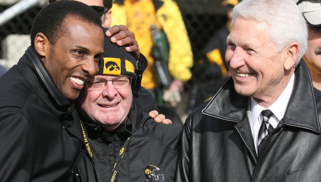 Former Iowa basketball player Ronnie Lester, left, and former basketball head coach Lute Olson, right, share a moment with UI athletic trainer John Streif, center, who had worked with the 1980 Iowa Final Four team that was honored before the Hawkeye football game Saturday, Oct. 31, 2009.