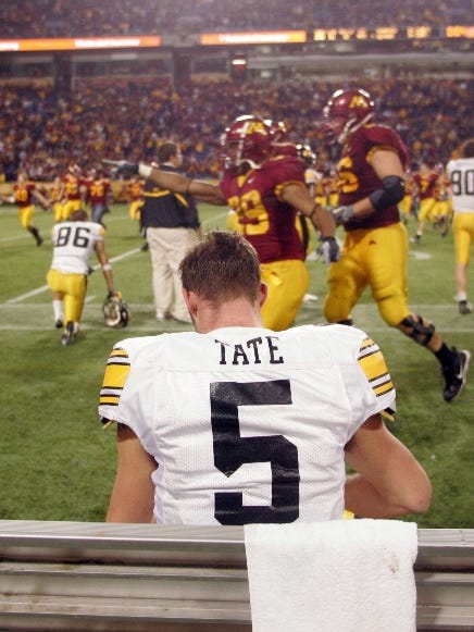 Iowa quarterback Drew Tate sits on the bench as Minnesota players rush to recover the Floyd of Rosedale, Saturday November 18,2006 at the Metrodome in Minneapolis, Minn. Minnesota won 34-24.