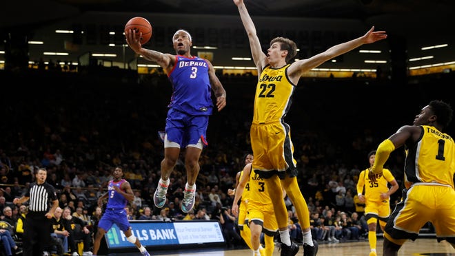 DePaul guard Devin Gage (3) drives to the basket ahead of Iowa forward Patrick McCaffery (22) during the first half of an NCAA college basketball game, Monday, Nov. 11, 2019, in Iowa City, Iowa. DePaul won 93-78. (AP Photo/Charlie Neibergall)