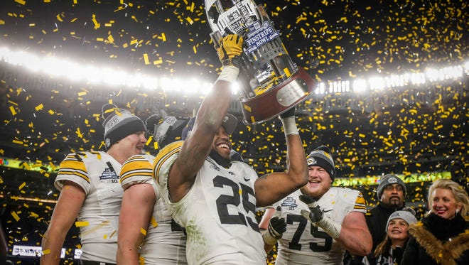 Iowa senior running back Akrum Wadley raises the 2017 Pinstripe Bowl trophy after the Hawkeyes beat Boston College, 27-20, during the 2017 Pinstripe Bowl at Yankee Stadium in Bronx, New York on Wednesday, Dec. 27, 2017.