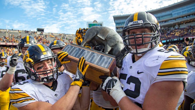 Iowa Hawkeyes wide receiver Riley McCarron (83) and Iowa Hawkeyes offensive lineman Boone Myers (52) hold up the floyd of rosedale trophy at TCF Ban after defeating the Minnesota Golden Gophers Stadium. The Hawkeyes won 14-7.